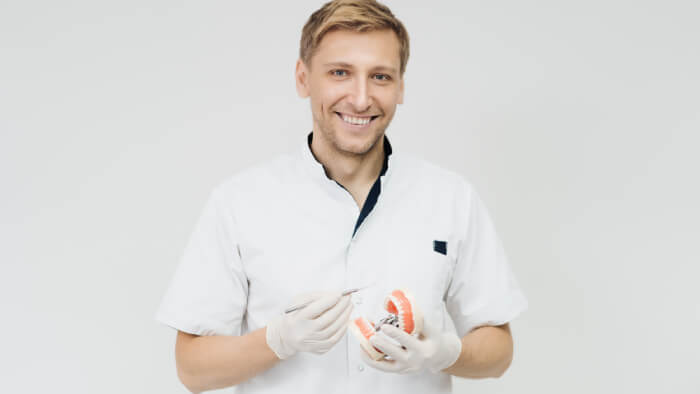 Medico stomatologo che tiene in mano un campione di mascella umana