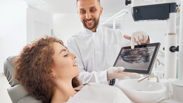 dentist showing xray pictures teeth to patient